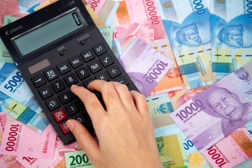 hand-typing-calculator-paper-currencies-background